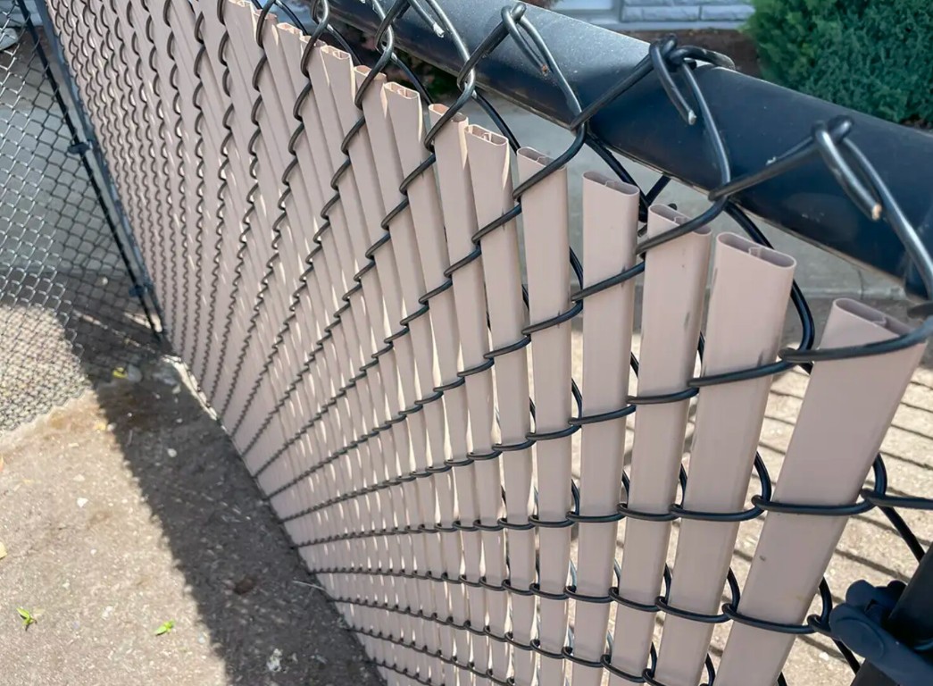 Commercial chain-link fence with privacy slats installation